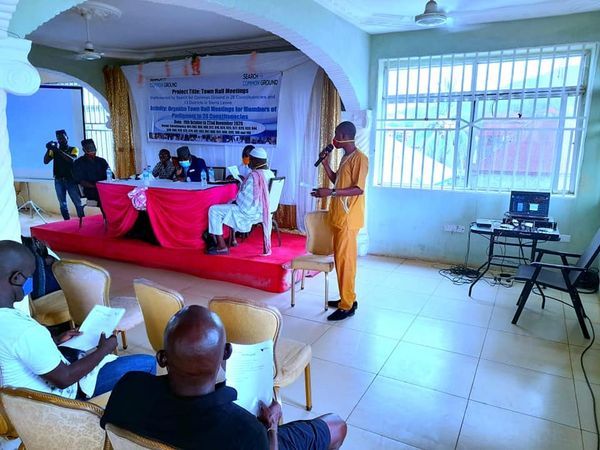 A community town hall meeting with speakers at the front